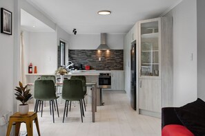 The open-plan living space with the kitchen, dining table and lounge area.