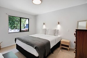 The main bedroom features a lovely Queen bed that invites you to sleep under its crisp, white sheets.