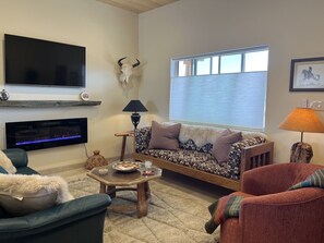 A comfortable and inviting living room with TV and yoga mats
