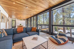 Take in breathtaking vistas through expansive floor-to-ceiling windows that grace the entire rear of the house, inviting natural light and picturesque views of the surrounding landscape into every corner of your living space