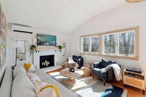Beautiful living room with couch, 2 chairs, and smart TV (note: Fireplace in-operable)