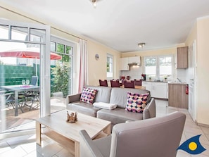 Wohnzimmer mit Essbereich, Küchenzeile und Zugang zur Terrasse