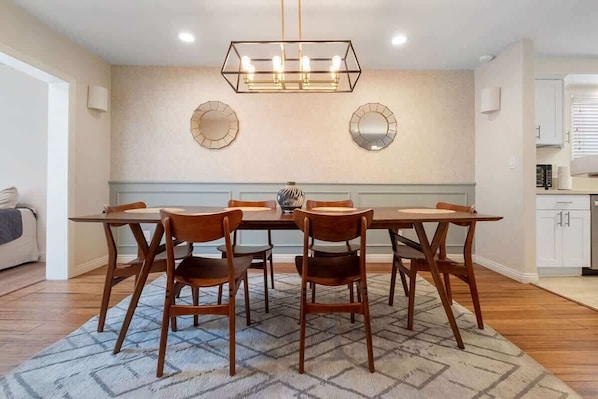 Elegant dining area with six chairs and complete set of tableware for the entire family.