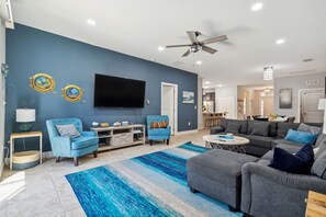 Living room with contemporary vibe complete with ceiling fan and TV rack