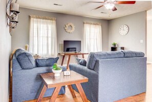 Modern & comfortable decor in living room, and windows overlooking green acres.