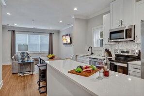 Open-concept floor plan seamlessly flowing the designer furnished living room with the fully equipped kitchen.