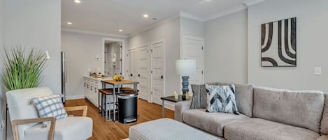 Open-concept floor plan seamlessly flowing the designer furnished living room with the fully equipped kitchen.