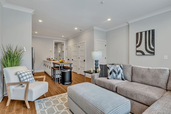 Open-concept floor plan seamlessly flowing the designer furnished living room with the fully equipped kitchen.