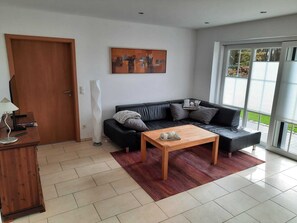 Ferienwohnung, 1-4 Pers., 110 qm.-helles Wohnzimmer mit Sofa und Blick in den Garten