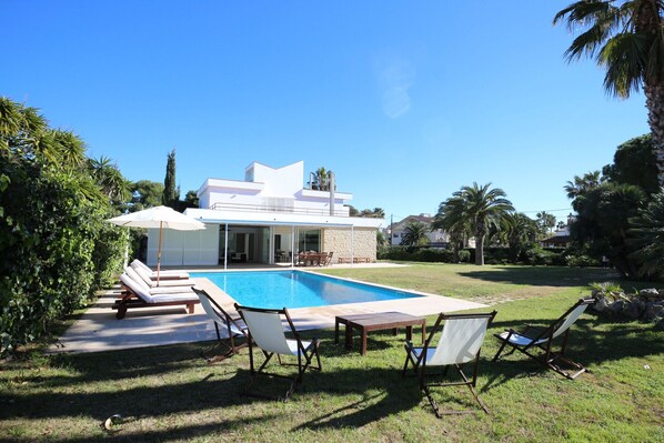 Swimming pool with plenty of sun loungers and ample poolside seating.