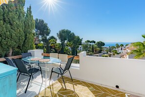 Large terrace with table and chairs, sun loungers and parasol to enjoy a spectacular sea view.