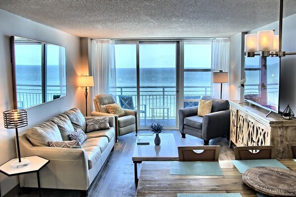From the kitchen through the dining and livingroom and balcony to the blue ocean