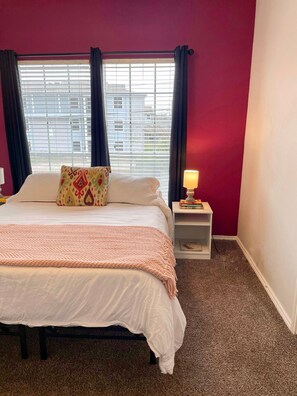 Spacious second bedroom with a cozy queen-sized bed and a large window for natural light!