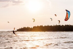 Waterfront Serenity: Immerse yourself in the vibrant energy of North Oliphant Beach as colorful kitesurfers dance across the horizon. This captivating scene is a mere glimpse of the aquatic adventures that lie just steps from The Louise. The sunset's golden hues reflecting on the water create a picturesque setting for guests to savor from the comfort of their beachside getaway.