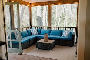 Whether you're seeking solitude and introspection or the company of loved ones, the screened porch with its inviting L-shaped couch offers the ideal space to relax, rejuvenate, and connect with the beauty of the natural world.