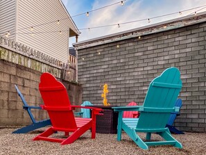Unwind under the stars with a cozy fire pit, twinkling string lights, a grill ready for BBQs, and life-size games for endless fun.