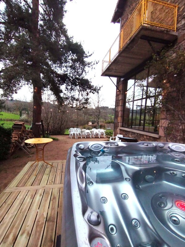 Jacuzzi sur une terrasse en bois dans un cadre naturel et relaxant