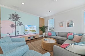 The palm trees make their way inside in our open layout designer living room. 