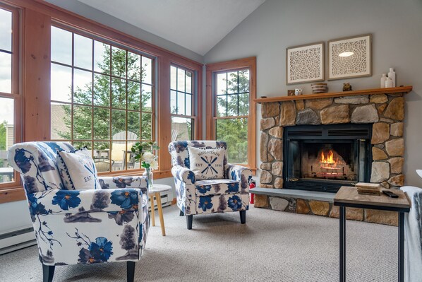 Cozy up by the charming stone fireplace—perfect for relaxing evenings with a warm drink and great company!