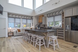 Well-equipped kitchen with island seating for 6, modern appliances, and drip-style coffee maker