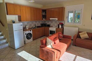 Kitchen area with fridge freezer, cooker, microwave, washing machine, kettle, toaster and all utensils.