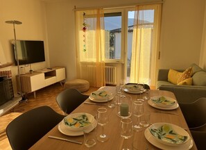 Spacious living room with dining table, sitting area and fireplace, TV and WLAN.