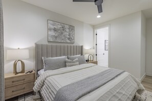 Main Bedroom Side View - The main bedroom is furnished with a plush King bed, private TV, and walk-in closet.