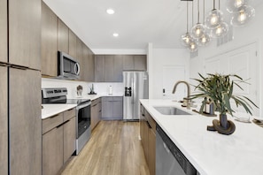 Whip up your favorite meals in a sleek kitchen equipped with state-of-the-art appliances, featuring a contemporary and inviting design.