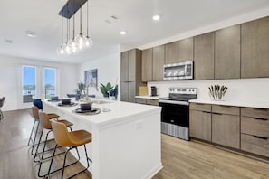 Whip up your favorite meals in a sleek kitchen equipped with state-of-the-art appliances, featuring a contemporary and inviting design.