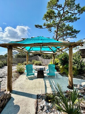 Shaded cabana area with string lights and a gas fire table!! Overlooks the pool