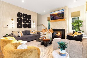 Imagine cozying up by the warm fireplace in this inviting living room, the perfect spot to relax after a day of exploring.