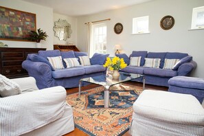 Lounge with two sofas, coffee table, armchair and pouffe