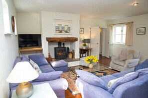 Lounge with sofas, fireplace and log burner, coffee table