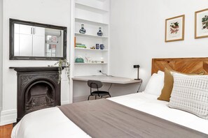 Find relaxation in the bedroom, where you can sink into the comfort of the queen-size bed and make use of the convenient work desk. Admire the ornate mirror and the original heritage decorative fireplace, adding to the room's charm and character.
