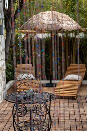 Relaxation area of your accommodation with outdoor dining area and sunbeds, perfect for unwinding at Mandara Beach.