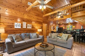 This living room is perfect for relaxing with loved ones, featuring a stone fireplace and large windows that bring in natural light.