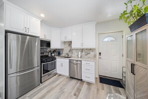 Fully-stocked kitchen w/custom built cabinets & granite countertops & backsplash