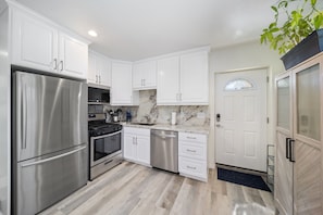 Fully-stocked kitchen w/custom built cabinets & granite countertops & backsplash