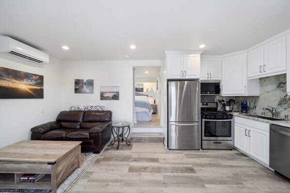 Living room & kitchen with step up into the separate bedroom w/queen size bed