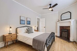 The master bedroom is complemented by high ceilings and a queen sized bed