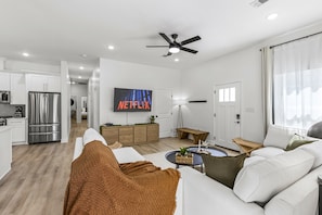 Cozy up on the couch for your favorite show in a 65“ smart TV after a long day at the beach.