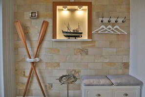Nautic Lounge 45 – Maritimes Detail mit Deko-Ruder, Modellschiff & Garderobe, stilvoll eingerichtet.