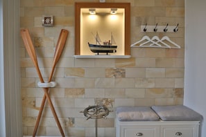 Nautic Lounge 45 – Maritimes Detail mit Deko-Ruder, Modellschiff & Garderobe, stilvoll eingerichtet.