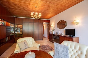 Ostsee Lodge – moderner Wohnbereich mit TV und gemütlicher Sitzecke, Ferienwohnung am Strand von Brodau.