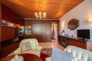 Ostsee Lodge – stilvoller Wohnbereich mit TV und gemütlichen Sesseln, Ferienwohnung am Strand von Brodau.