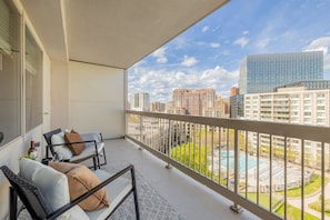 Relax on the large balcony with city skyline and pool view