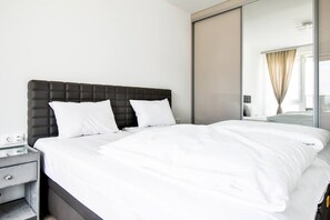 Recharge in style in this tranquil bedroom, where the plush European king-sized bed awaits to envelop you in comfort. Crisp, white linens promise a restful sleep, while the sleek, dark headboard adds a touch of modern sophistication to your private oasis. Floor-to-ceiling mirrored wardrobes reflect natural light, enhancing the airy, open feel of the room. This space is not just...