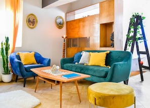 “Sink into style—retro armchairs, warm wood, and joyful colors await.”
➡️ Perfect for slow mornings and late-night chats.