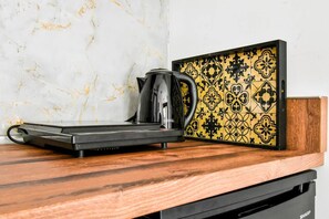 Morning essentials: sleek hotplate and kettle set against marbled elegance.