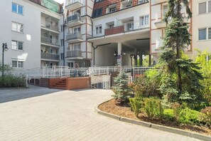 A communal or private outdoor area surrounded by buildings, with trees and plants visible.